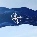 NATO flag waving against blue sky