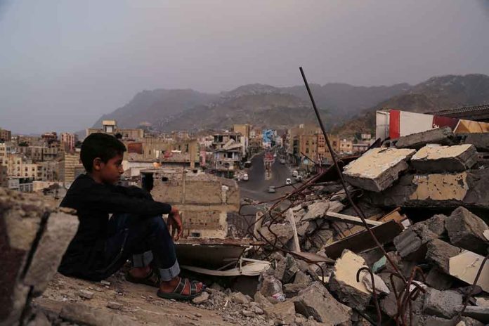 1673317843 featured image Boy amidst rubble with cityscape and mountains in background