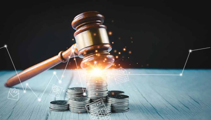 2094447643 featured image Gavel, coins, and tax icons on a table