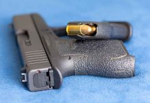 Handgun on blue fabric with visible bullet cartridge