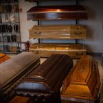 Wooden coffins and urns displayed in a showroom