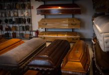 Wooden coffins and urns displayed in a showroom