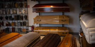 Wooden coffins and urns displayed in a showroom