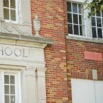 Brick school building with windows and foliage