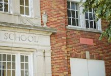 Brick school building with windows and foliage
