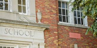 Brick school building with windows and foliage