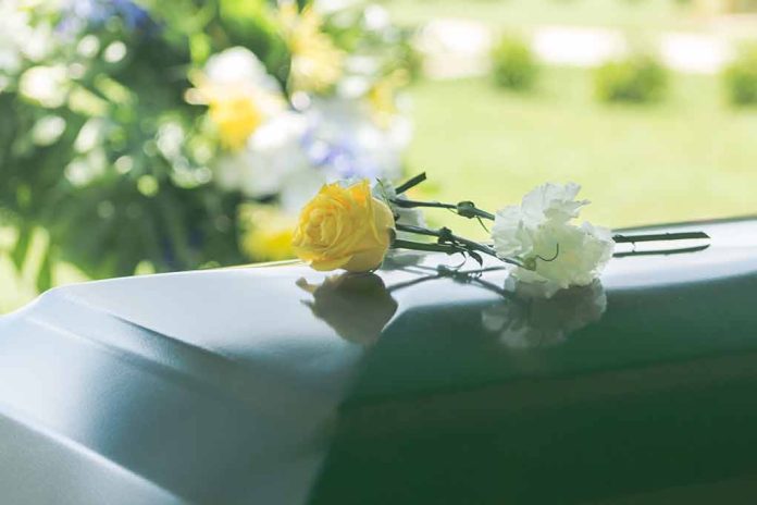1014454810 featured image Two flowers on a casket at a funeral