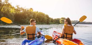 Two people kayaking on a sunny river