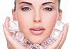 Woman holding ice cubes near her face