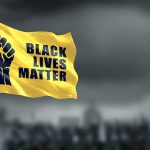 Yellow Black Lives Matter flag with clenched fist
