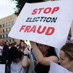 People holding Stop Election Fraud protest signs
