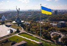 Large Ukraine flag with cityscape in background