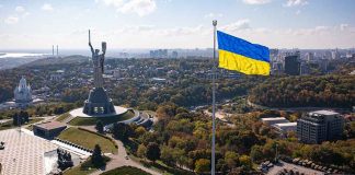 Large Ukraine flag with cityscape in background
