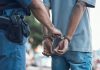 Police officer handcuffing a person outdoors