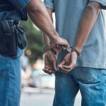 Police officer handcuffing a person outdoors