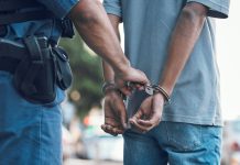 Police officer handcuffing a person outdoors
