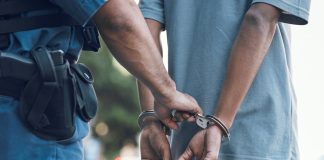 Police officer handcuffing a person outdoors