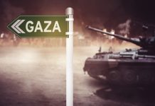 Sign pointing to Gaza with tank nearby