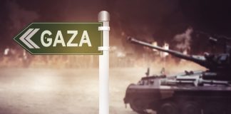 Sign pointing to Gaza with tank nearby