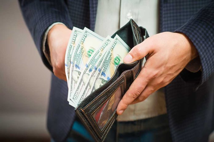 253526959 featured image Wallet filled with hundred dollar bills being held