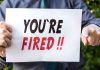 Person holding YOU ARE FIRED sign