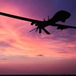 Silhouette of a drone against a colorful sunset