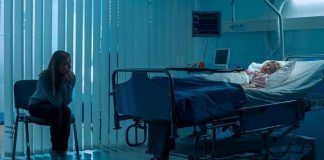 Woman sitting beside hospital bed at night