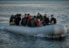People on a packed raft in open water.