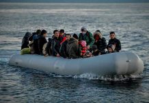People on a packed raft in open water.