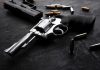Revolvers and bullets on a dark surface