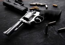 Revolvers and bullets on a dark surface