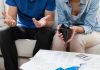Couple looking at empty wallet and bills