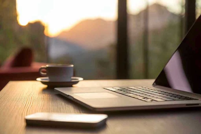 350692013 Laptop, coffee cup, and phone on wooden table.