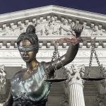 Lady Justice statue in front of courthouse