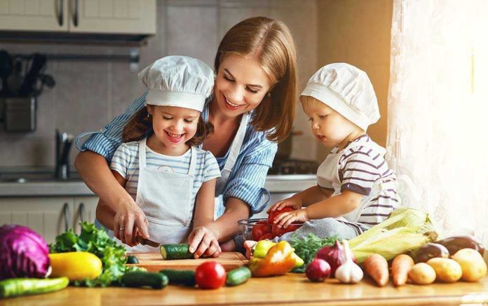 680767063 Family cooking together with vegetables in kitchen
