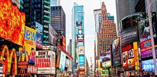 Times Square crowded with people and bright electronic advertisements