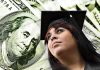 Young woman in graduation cap looking upward with money in the background