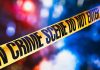 Yellow crime scene tape with blurred lights background.