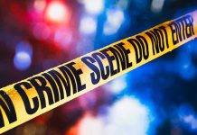 Yellow crime scene tape with blurred lights background.