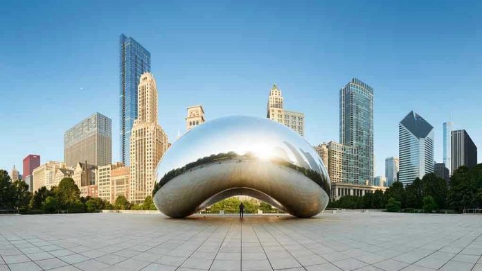 1075027280 Cloud Gate sculpture with skyline of skyscrapers behind it.