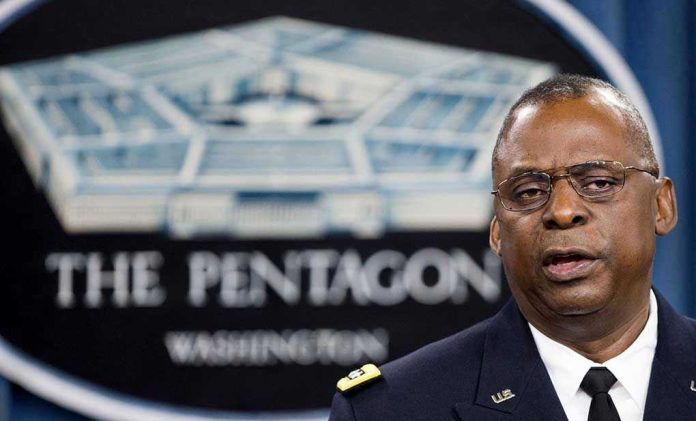 2027618987 Man speaking in front of Pentagon sign.