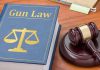 "Gun Law" book and gavel on wooden desk.
