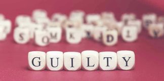 Dice spelling "GUILTY" on a red surface.