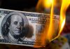 Burning hundred-dollar bill with visible flames.