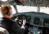 Pilot in cockpit operating airplane controls.