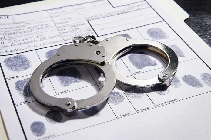 608376650 Handcuffs on fingerprint form with fingerprints visible.