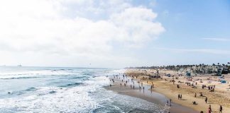 Crowded beach with waves and people enjoying sun