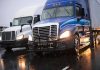 Truckers PANIC – Strict Requirement Introduced! Two trucks driving on a wet road.