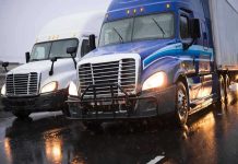 Truckers PANIC – Strict Requirement Introduced! Two trucks driving on a wet road.