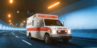 Ambulance driving through a brightly lit tunnel.